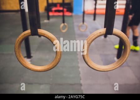 Tradizionali anelli di ginnastica in legno appesi all'interno Foto Stock