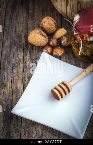 noci in miele e noci di vari tipi, miele cucchiaia Foto Stock