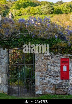 una scatola postale d'epoca in vecchio stile incastonata in un vecchio muro di pietra nel villaggio di mottilstone sull'isola di wight. Foto Stock