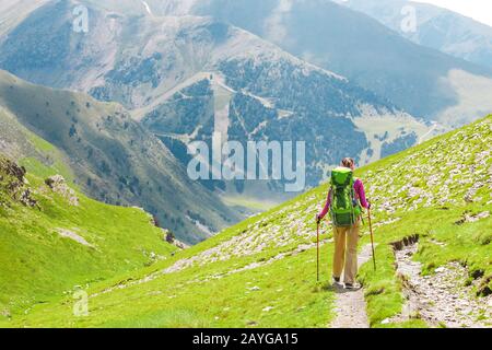 ragazza hiker con pali che camminano al prato highland Foto Stock