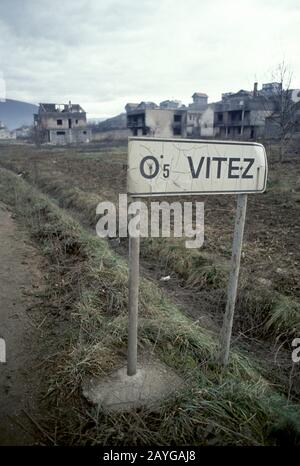 8th gennaio 1994 pulizia Etnica durante la guerra in Bosnia centrale: Case e edifici bruciati costituiscono lo sfondo per un cartello stradale a Vitez nel sobborgo settentrionale di Grbavica. Foto Stock