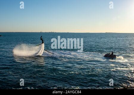 Imbarco con moto d'acqua estremi a Ras al Khaimah, Emirati Arabi Uniti vicino a Dubai al tramonto divertendosi sull'acqua. Ricreazione e sp Foto Stock