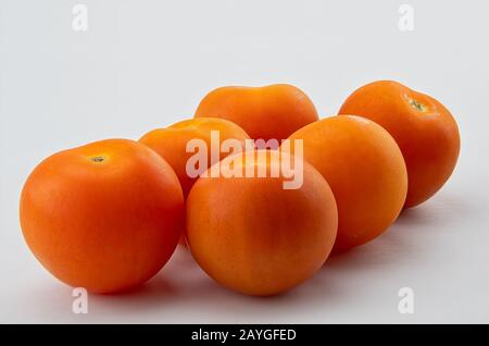 Sei pomodori da insalata su sfondo bianco Foto Stock