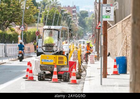 28 LUGLIO 2018, BARCELLONA, SPAGNA: Operai e macchine pesanti che riparano la strada Foto Stock