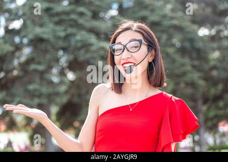 Donna asiatica con microfono vivavoce come pianificatore professionale di nozze Foto Stock