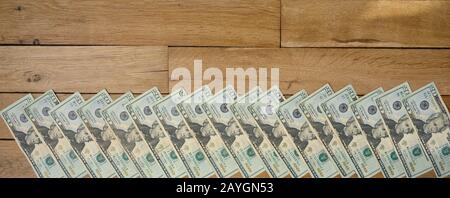 Banner formato sfondo di dollari usati 20 banconote in dollari giacenti su tavola di legno. Verso l'alto (faccia). Foto Stock