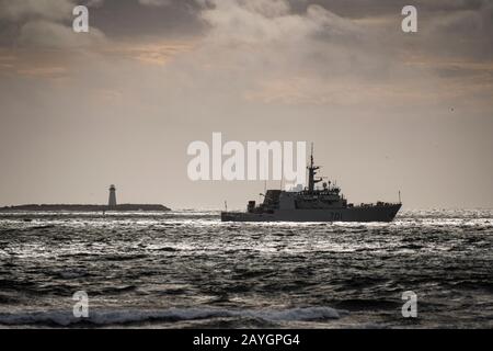 Royal Canadian Navy Maritime Coastal Defense Vessel (MCDV) HMCS GLACE BAY parte dal porto di Halifax passando davanti al faro sull'isola di McNab. Foto Stock