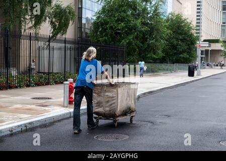 Povero uomo o senzatetto che spinge un carro su una strada a Manhattan, New York City, USA Foto Stock