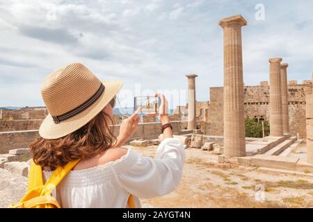 Ragazza turistica scattare foto e selfie di attrazione turistica dell'antica città dell'Acropoli. Destinazioni di viaggio e visite turistiche Foto Stock