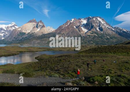 Persone che fotografano il Massiccio Paine con il Cuernos del Paine (Horns) e il Monte Ammiraglio Nieto (a destra) nel Parco Nazionale Torres del Paine a sud Foto Stock