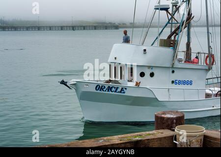 Newport, Oregon, USA - 23 agosto 2015: Un pescatore pilota la sua barca nel porto turistico di Yaquina Bay, a Newport, sulla costa dell'Oregon Foto Stock