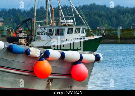 Newport, Oregon, USA - 25 maggio 2016: Primo piano di una barca che si appende al suo fianco mentre un'altra imbarcazione si trova dietro la costa del porto turistico di Newport on t Foto Stock