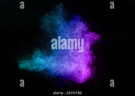 Il movimento di congelamento della polvere di colore blu e rosa esplode su sfondo nero. Foto Stock