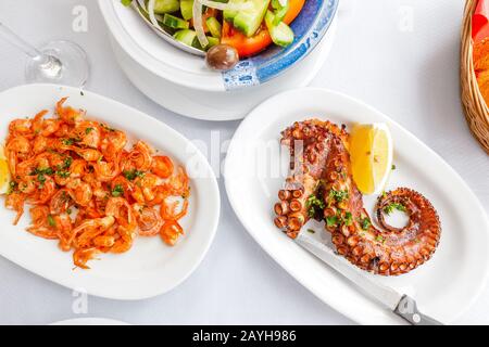 Vista dall'alto di gamberetti grigliati e polpo su un tavolo in un ristorante di pesce Foto Stock