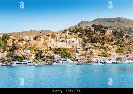 Isola colorata Symi - popolare attrazione turistica con barche da pesca in un porto Foto Stock