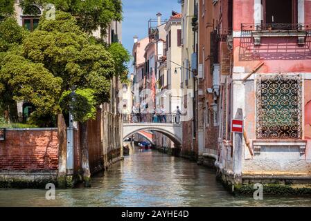 Venezia, Italia - 18 maggio 2017: I turisti sono sul ponte sopra lo stretto canale. Un canale a Venezia è una strada della città. Vista dal Canal Grande. Foto Stock