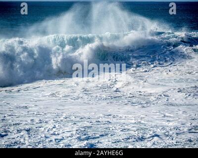 Grandi onde sulla costa settentrionale di Oahu con mare acquamarina, schiuma bianca e cieli blu. Foto Stock