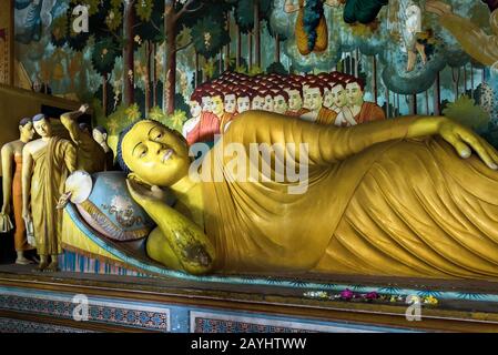 Dickwella, Sri Lanka - 4 novembre 2017: Statua di Buddha reclinato all'interno del tempio buddista di Wewurukannala. Interni lussuosi dell'antico buddista p Foto Stock