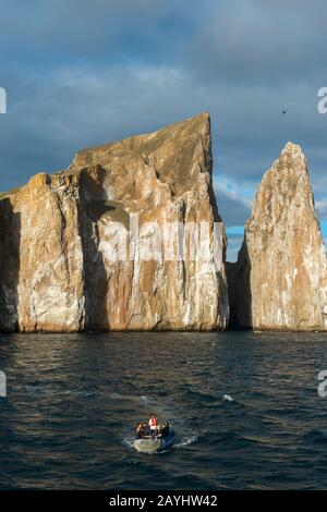 Vista della roccia di Kicker vicino all'Isola di San Cristobal (Isla San Cristobal) o all'Isola di Chatham, alle Isole Galapagos, Ecuador con zodiaco in primo piano. Foto Stock