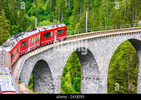 Landwasser Viaduct primo piano, Svizzera. E' famoso punto di riferimento della Svizzera. Treno espresso rosso su ponte alto in montagna. Vista panoramica della sorprendente railwa Foto Stock