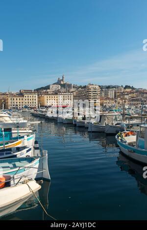 Il Porto Vecchio con le barche a Marsiglia, Francia con Notre-Dame de la Garde (Nostra Signora della Guardia), una basilica cattolica nel backgrou Foto Stock