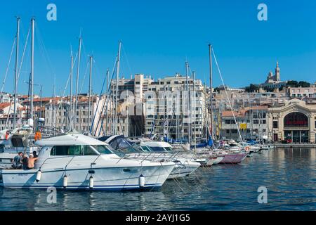 Il Porto Vecchio con le barche a Marsiglia, Francia con Notre-Dame de la Garde (Nostra Signora della Guardia), una basilica cattolica nel backgrou Foto Stock