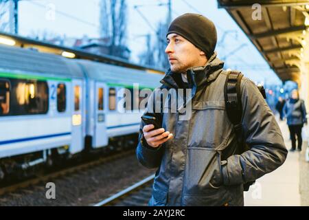 Sopot Stazione ferroviaria urbana veloce. Giovane uomo in piedi e in attesa di treno sulla piattaforma. Viaggi turistici in treno. Ritratto Di Maschio Caucasico In Ferrovia Foto Stock