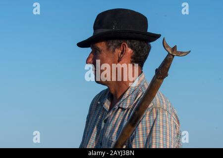 Ritratto di un guardiano (cowboy Camargue) con un tridente sul suo cavallo su una spiaggia della Camargue nel sud della Francia. Foto Stock