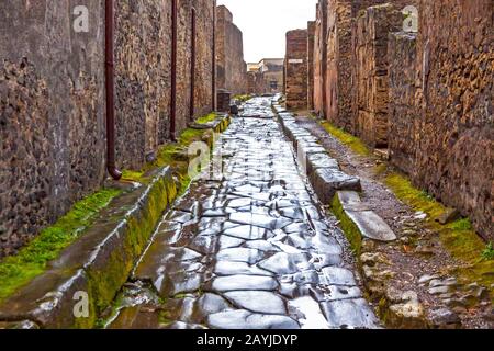 Strada asfaltata presso l'antica città romana di Pompei, Italia. Pompei fu distrutta e sepolta durante l'eruzione del Vesuvio nel 79 d.C. Foto Stock