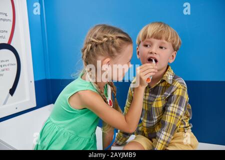 Ragazza che gioca orecchio naso gola specialista. Foto Stock