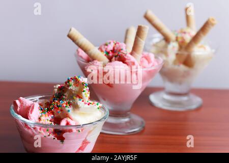 Gelato alla vaniglia e alla fragola servito in bicchieri, con spruzzette dolci e, Bogotá Colombia, 15 febbraio 2017 Foto Stock