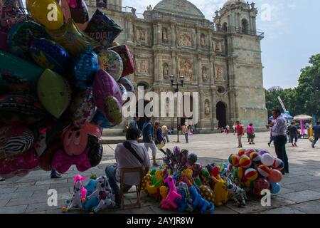 Persone che vendono palloncini sulla piazza di fronte alla Cattedrale Di Nostra Signora dell'Assunzione costruita in stile neoclassico, nella città di Oaxaca de Foto Stock