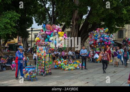 Persone che vendono palloncini sulla piazza di fronte alla Cattedrale Di Nostra Signora dell'Assunzione nella città di Oaxaca de Juarez, Oaxaca, Messico. Foto Stock