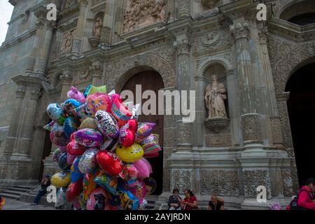Persone che vendono palloncini sulla piazza di fronte alla Cattedrale Di Nostra Signora dell'Assunzione costruita in stile neoclassico, nella città di Oaxaca de Foto Stock