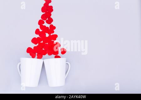 Porcellana Bianca la tazza con il glitter cuore coriandoli. Il giorno di San Valentino del concetto. Trendy in stile minimalista piatto design laici dello sfondo. Posizione orizzontale Foto Stock