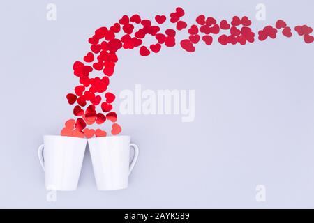 Porcellana Bianca la tazza con il glitter cuore coriandoli. Il giorno di San Valentino del concetto. Trendy in stile minimalista piatto design laici dello sfondo. Posizione orizzontale Foto Stock