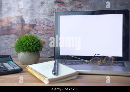 computer portatile, blocco note e calcolatrice sulla scrivania Foto Stock