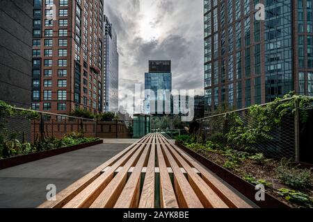 New YORK, USA - OTTOBRE 07: Vista di edifici moderni e panchina al High Line Park, una popolare destinazione di viaggio il 07 ottobre 2019 a New York Foto Stock