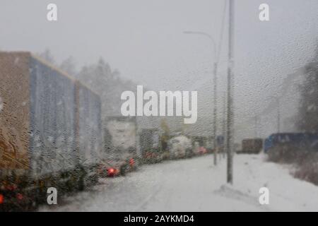 Automobili su traffico stradale invernale JAM città. Tempo invernale sull'autostrada della città, la vista dalla polizia pattuglia auto attraverso la finestra di vetro steamy nella nebbia e s. Foto Stock