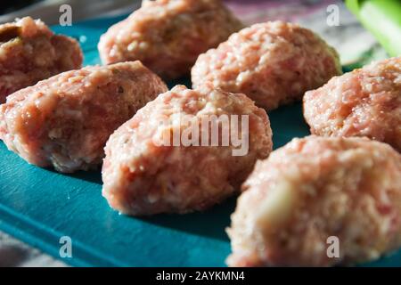 Cotolette di carne macinate fatte in casa a base di ingredienti naturali pronte per friggere in una padella. Messa a fuoco selettiva. Foto Stock