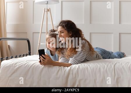 Buona famiglia di bonding guardare divertenti cartoni animati sullo smartphone. Foto Stock