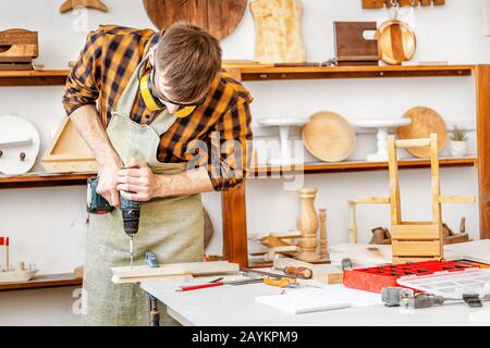 Falegname uomo al lavoro a casa o in officina. Concetto di esperienza artigianale Foto Stock