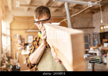 Falegname uomo che lavora con pezzi di legno in cantiere. Concetto di riparazione e lavoro Foto Stock