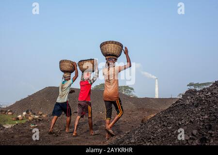 Il lavoratore trasporta il cesto di carbone che deve essere usato nel forno di un brickfield.Khulna, Bangladesh. Foto Stock