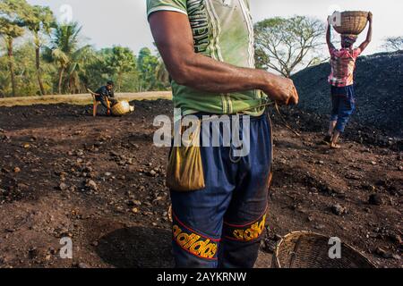 Il lavoratore trasporta il cesto di carbone che deve essere usato nel forno di un brickfield.Khulna, Bangladesh. Foto Stock