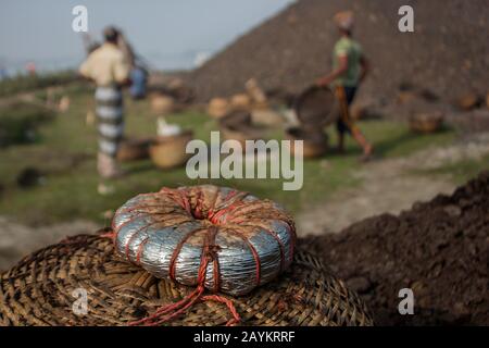 Il lavoratore trasporta il cesto di carbone che deve essere usato nel forno di un brickfield.Khulna, Bangladesh. Foto Stock