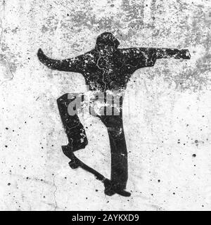 Graffiti stencil a tema skate. Vista di un graffiti stencil a tema skateboard di un artista non identificato su pareti grungy. Può essere usato come urb Foto Stock