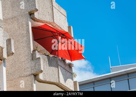 Ombrelloni e ombrelloni sui balconi di un alto edificio di appartamenti in Europa Foto Stock