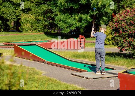 Persone che giocano a minigolf in una bella giornata estiva soleggiata Foto Stock
