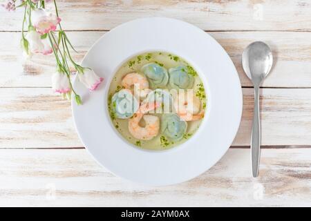 Gnocchi di zuppa e gamberetti serviti con porri. Su vecchio sfondo bianco di legno. Foto Stock